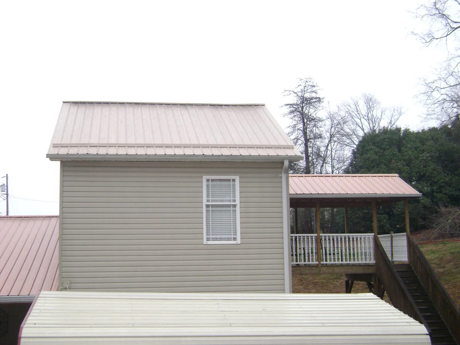 Tan metal roofs on a two story addition and attached porch, from a Roof Replacement job in Elverta
